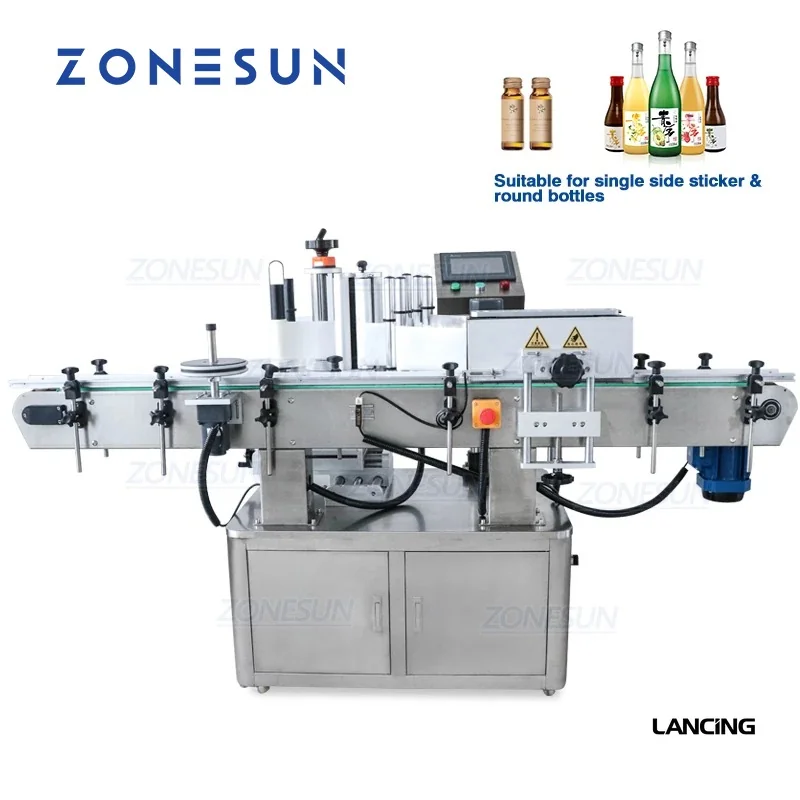 Round-bottle labelling machine with label rollers, a control screen and a conveyor.